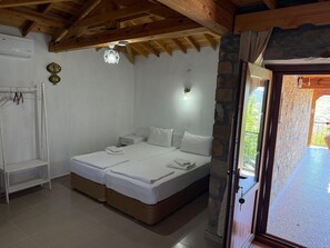 Un dormitorio con techo de madera, una cama con ropa de cama blanca, una mesita de noche pequeña y un reloj en la pared.