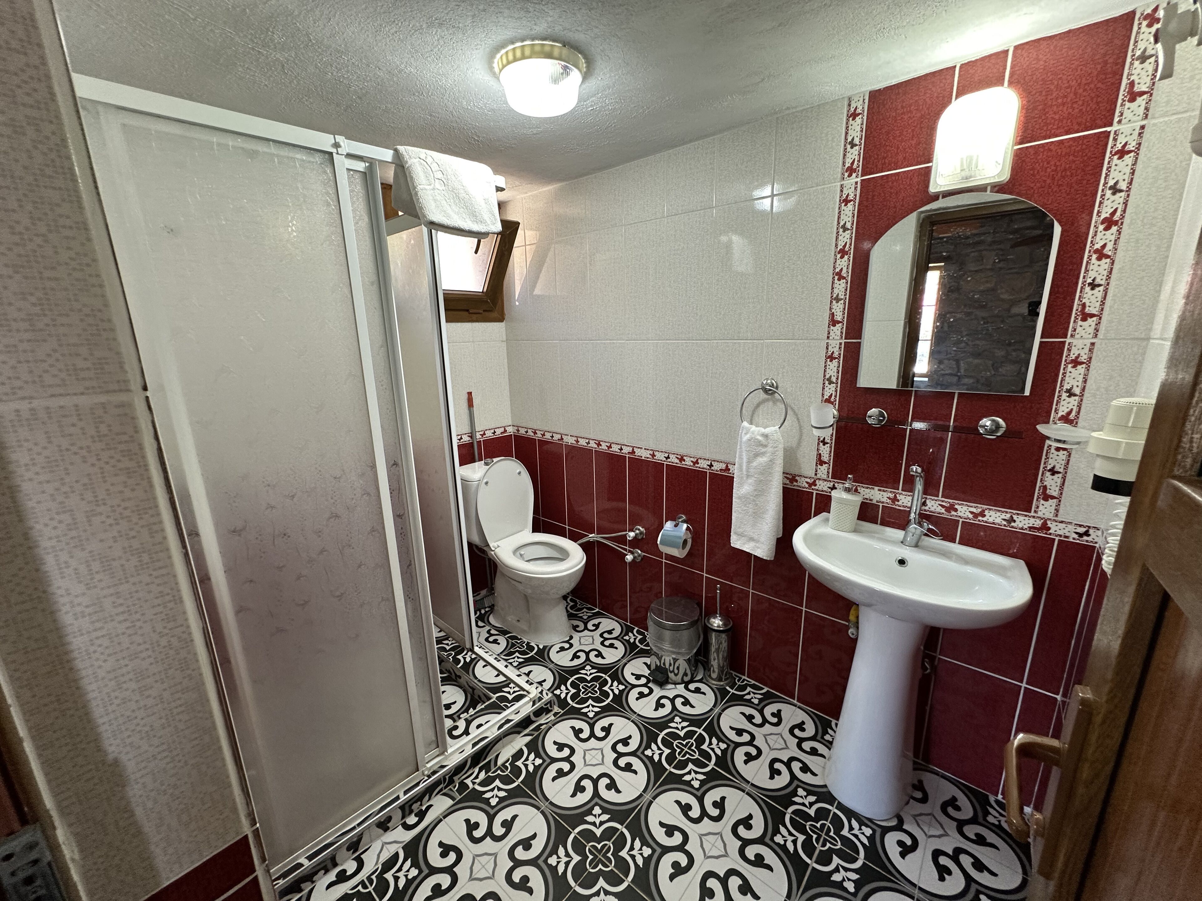 A bathroom with a toilet, sink, and shower.