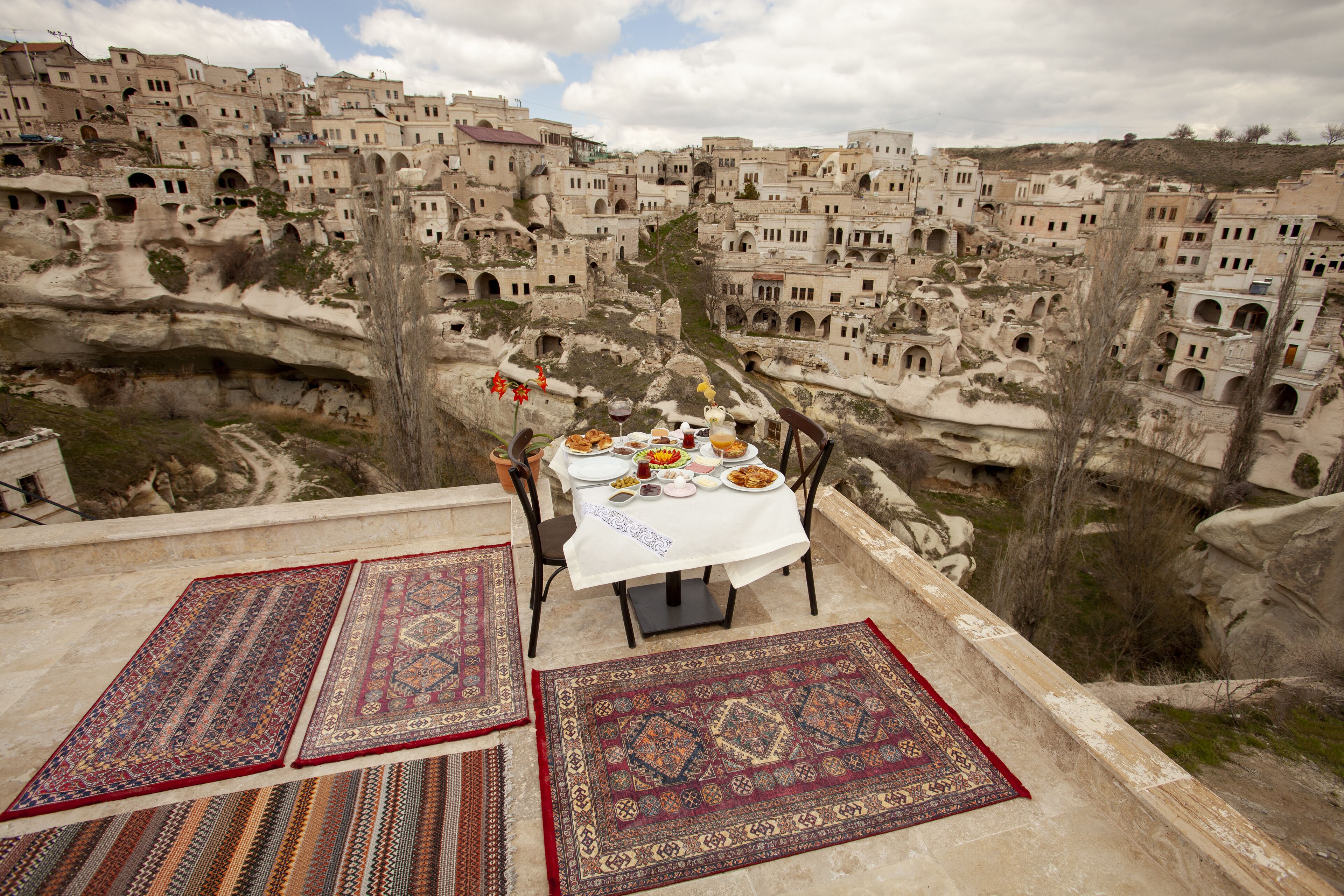 Una mesa dispuesta con comida y vistas a un pueblo de arquitectura tradicional.