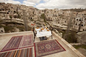 A table set with a meal and a view of a village with traditional architecture.