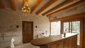 Una cocina rústica con vigas de madera, una isla grande y vistas al exterior.