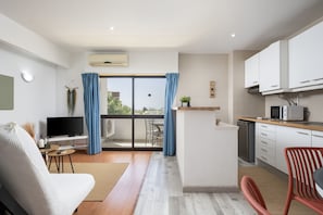 A modern apartment with a living room, kitchen, and balcony.