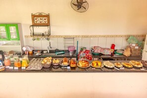 A buffet counter with various food items and condiments. - Pousada Luz do Sol (Paraty)