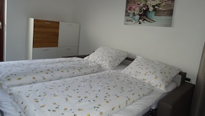 A double bed with floral bedding, a wooden wardrobe, and a floral painting on the wall. - Cozy apartment on the farm Vöran / Hafling (Vöran)
