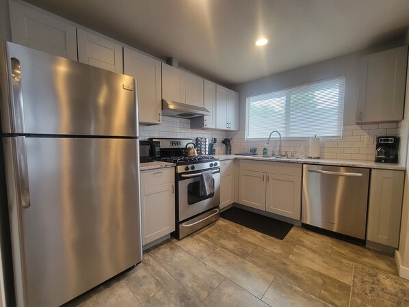 A modern kitchen with stainless steel appliances, a gas stove, and a dishwasher.