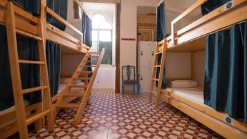 Un dormitorio con literas, una escalera, una silla y suelo de baldosas.