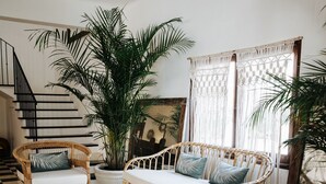 A room with a checkered floor, wicker furniture, and a staircase. - La Bohemia del Rio Hostal Boutique - Adults Only (Santa Eulalia del Rio)