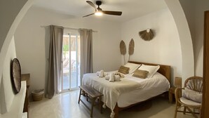 A bedroom with a bed, a ceiling fan, a bench, and a chair. - La Bohemia del Rio Hostal Boutique - Adults Only (Santa Eulalia del Rio)