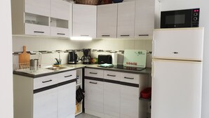 A compact kitchen with white cabinets, a microwave, a coffee maker, and a toaster. - Whole house (Belvedere)
