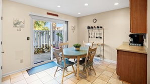 A kitchen with a dining table, chairs, a coffee maker, and a clock on the wall. - 3 Min Walk to Beach-Perfect for Families-Pet Friendly (North Myrtle Beach)