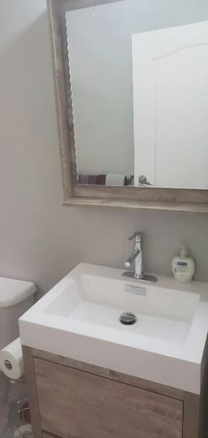 Chuveiro, toalhas de banho, sabonete, papel higiênico