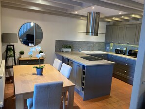 A modern kitchen with a central island, grey cabinets, and a stainless steel range hood. - Charming Countryside Cottage, Diptford Near Totnes (Totnes)