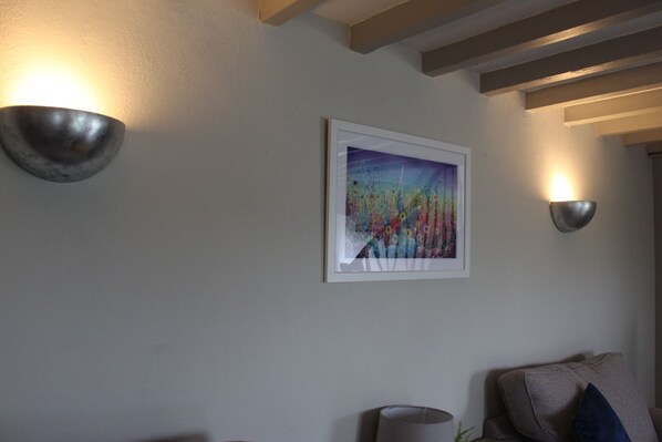 A room with a framed abstract painting on the wall, a lamp, and a couch. - Charming Countryside Cottage, Diptford Near Totnes (Totnes)