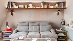 Un accogliente soggiorno con un divano decorato, una libreria in legno e un tavolino.