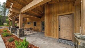 A wooden cabin with a covered porch, stone pillars, and a door with a number '4' sign.