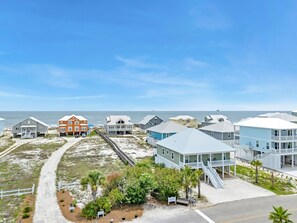 Une zone résidentielle côtière avec des maisons, une plage et un ciel dégagé.
