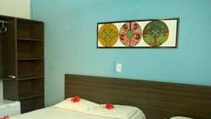 Una habitación con dos camas, un cabecero de madera y una pared decorada con tres obras de arte circulares.