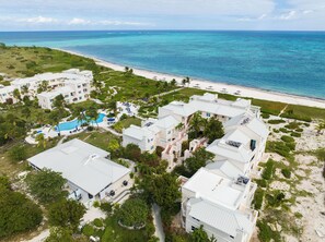 Une vue aérienne d’un complexe hôtelier comprenant plusieurs bâtiments, une piscine et une plage.
