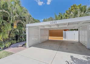Surrounded by lush greenery, this tranquil outdoor space features a wooden bench and a metal fence.