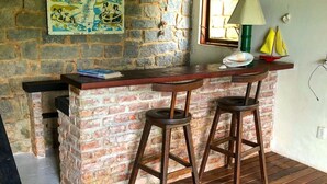 Eine rustikale Bar mit Backsteinwand, Holzstühlen und einer Karte an der Wand.