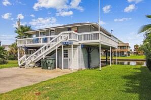 A two-story building with a balcony and a staircase. - Barnacle Lodge by Ryson Vacation Rentals (Galveston)