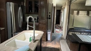 A compact kitchen with a sink, cabinets, and a refrigerator. - Paradise in Key Largo Florida 2 (Key Largo)