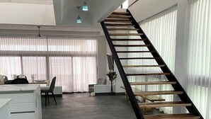 Un interior moderno con una escalera, un comedor y una cocina.