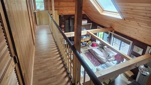A wooden interior with a sloped ceiling, a staircase, and a view of a living area below. - Lake House on Great Moose Lake with dock, swimming area, boat landing, and more! (Hartland)