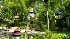 A lush garden with a pool, lounge chairs, and a gazebo. - Penthouse getaway by the beach (Ocho Rios)