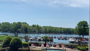 A marina with boats docked, surrounded by lush greenery and a clear sky.