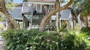 A two-story house with a covered porch and a staircase leading to the upper level.