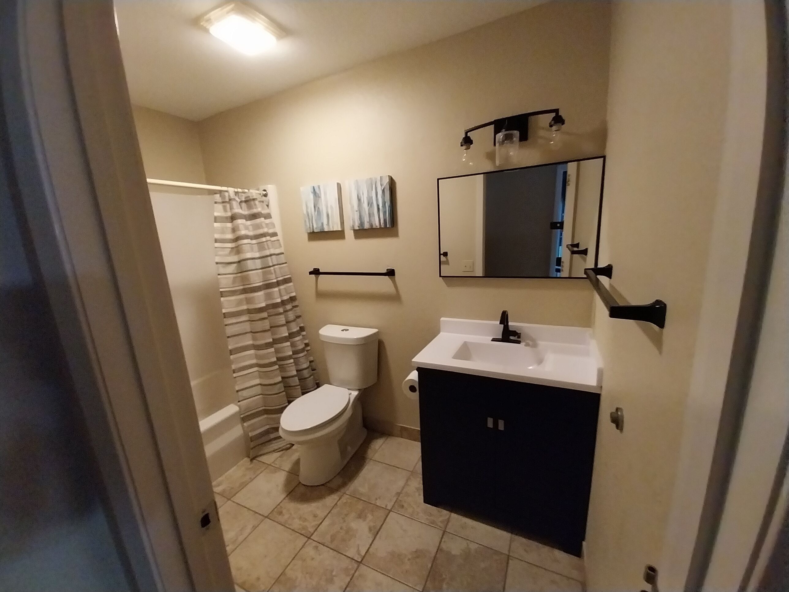 Een badkamer met toilet, wastafel en douchegordijn.