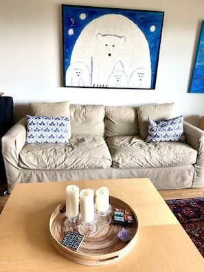 Relax in this inviting living room with a sofa, abstract art, and a wooden table.