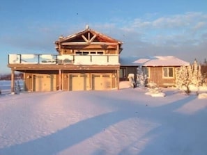 Situated in a serene winter landscape, this cozy lodge offers a balcony with a view of the surrounding area.