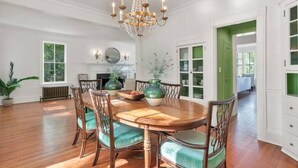 A dining room with a wooden table, green upholstered chairs, and a chandelier. - ★ LUXURY 5 BR VILLA Heart of Village Steps From #2 (Pinehurst)