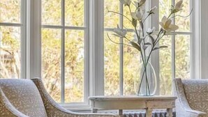 A room with a large window, a radiator, and two patterned armchairs. - ★ LUXURY 5 BR VILLA Heart of Village Steps From #2 (Pinehurst)