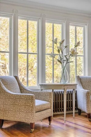 A room with a large window, a radiator, and two patterned armchairs. - Luxury 5 BR Villa Heart of Village Steps From #2 (Pinehurst)