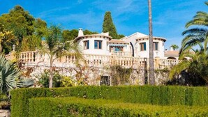 Un edificio grande e histórico con varios pisos, que cuenta con un patio central y una palmera destacada.