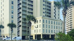 Un hôtel à plusieurs étages doté de balcons, d’une tour centrale et d’une enseigne sur laquelle on peut lire « BOARDWALK ».