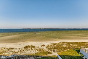 A beach view with a pathway leading to a building. - Waterfront Condo on Pensacola Beach (Pensacola Beach)