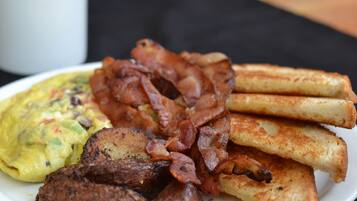 A plate of food including bacon, toast, and scrambled eggs.