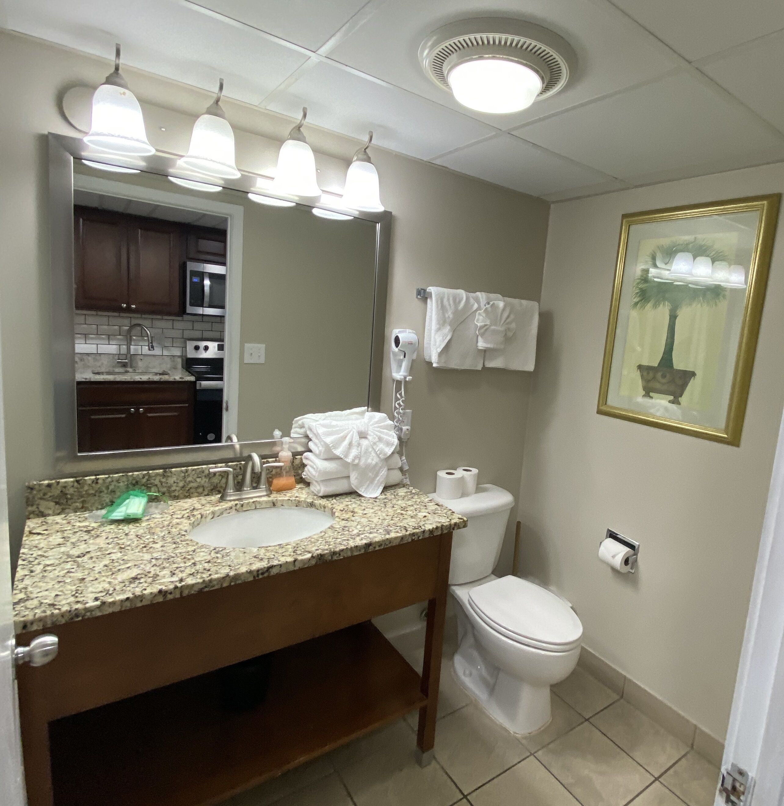 A bathroom with a sink, mirror, toilet, and towel rack.