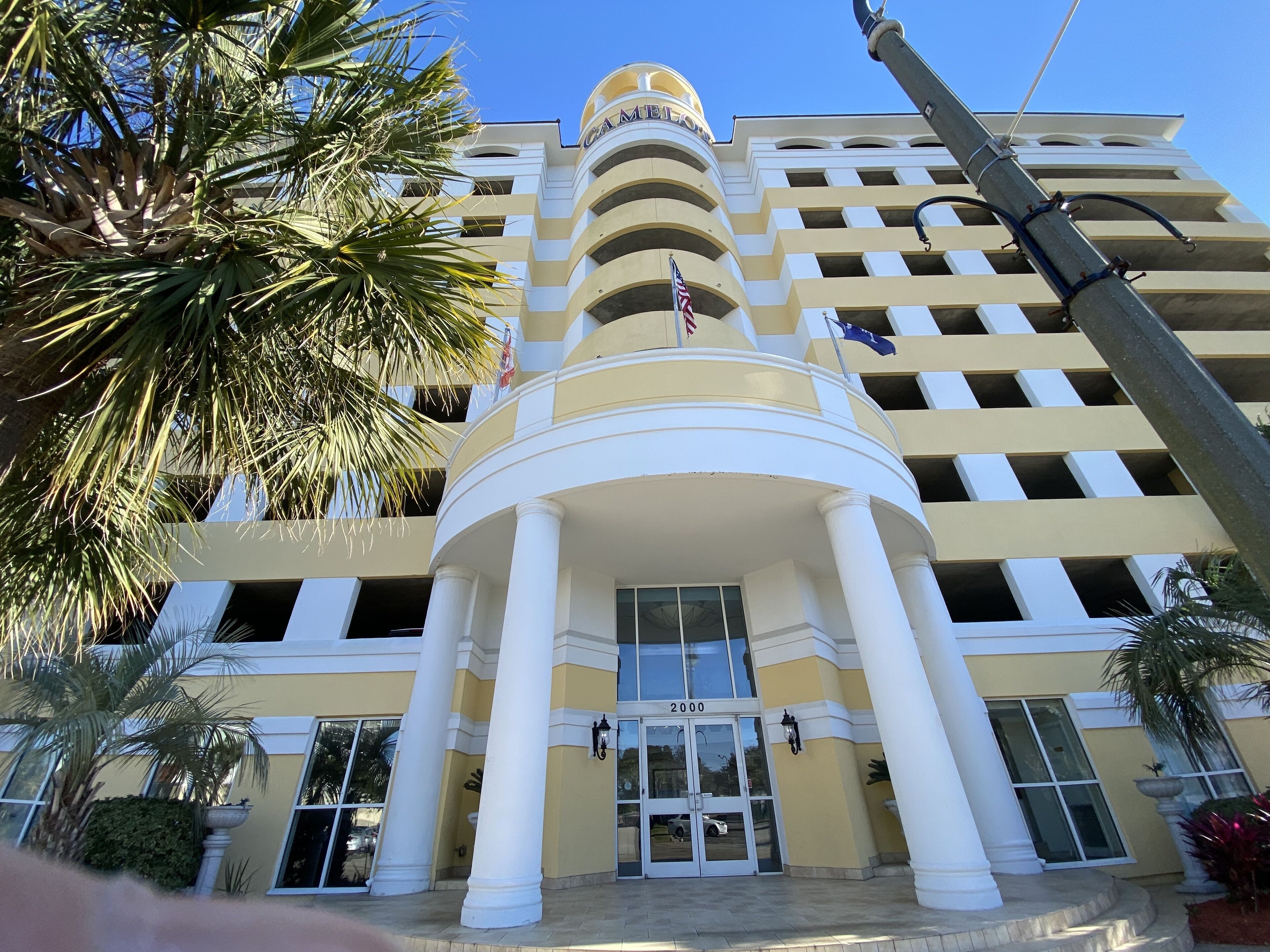 A hotel with a central entrance, multiple floors, and a flag.