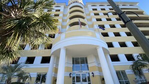 A hotel with a central entrance, multiple floors, and a flag.