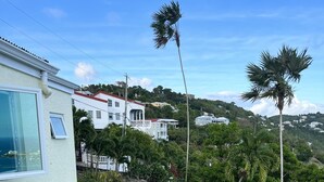 A residential property with a swimming pool, a patio, and a view of a hillside with houses. - Enjoy Caribbean Sun in Paradise with Privacy, Pool, and Panoramic View, Sleeps 8 (St Thomas)