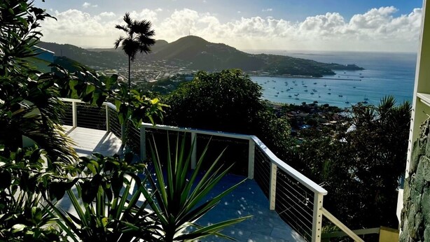 A balcony with a view of a coastal town, a mountain, and the sea. - Enjoy Caribbean Sun in Paradise with Privacy, Pool, and Panoramic View, Sleeps 8 (St Thomas)