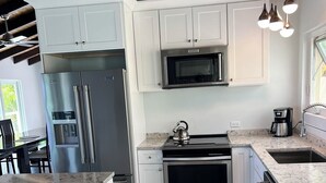A modern kitchen with white cabinetry, stainless steel appliances, and a marble countertop. - Enjoy Caribbean Sun in Paradise with Privacy, Pool, and Panoramic View, Sleeps 8 (St Thomas)
