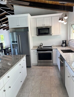 Enjoy cooking in this well-equipped kitchen with a refrigerator, microwave, and oven, plus ample workspace on the large island.