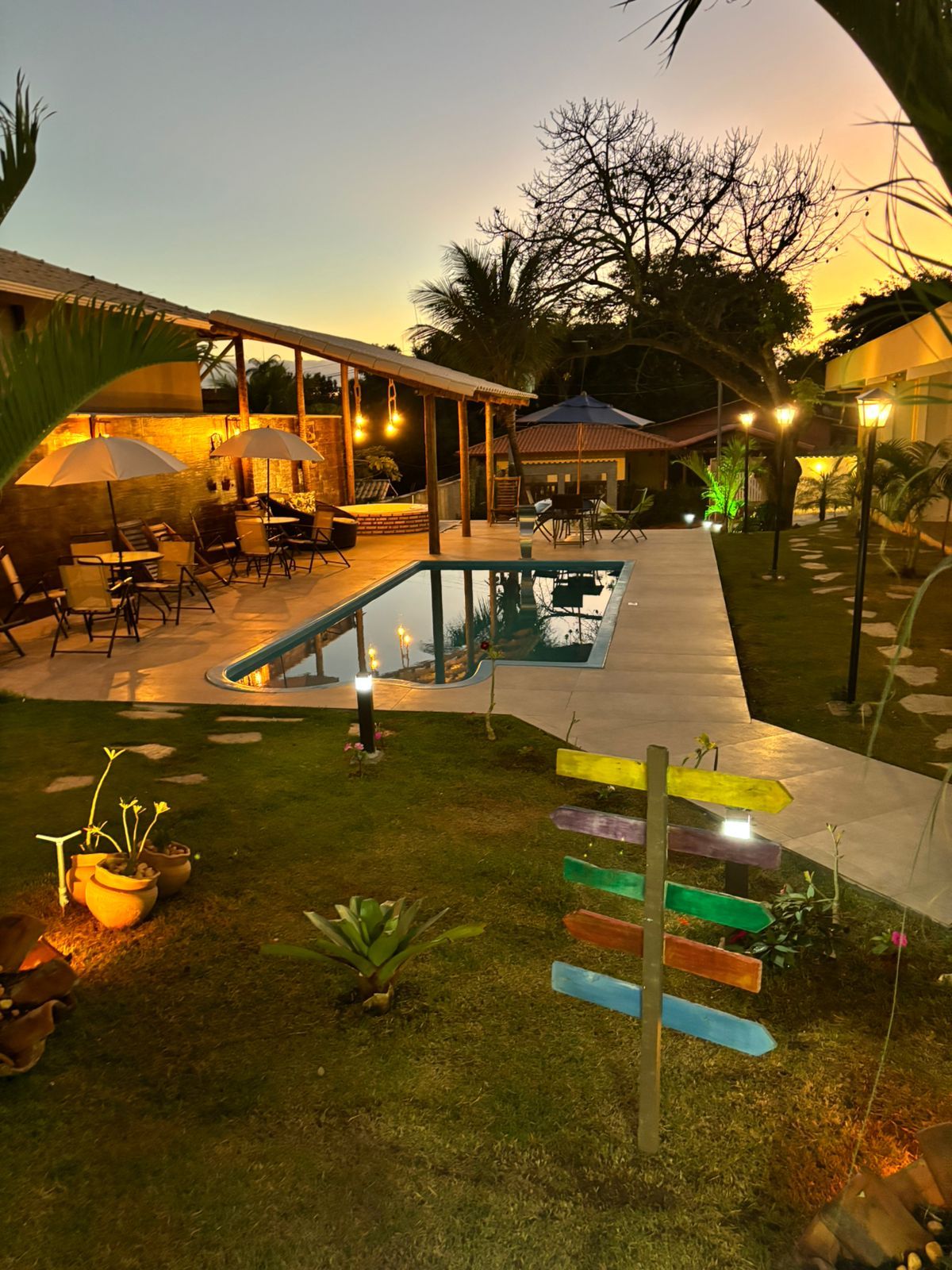 A pool area with a covered seating area and outdoor furniture.