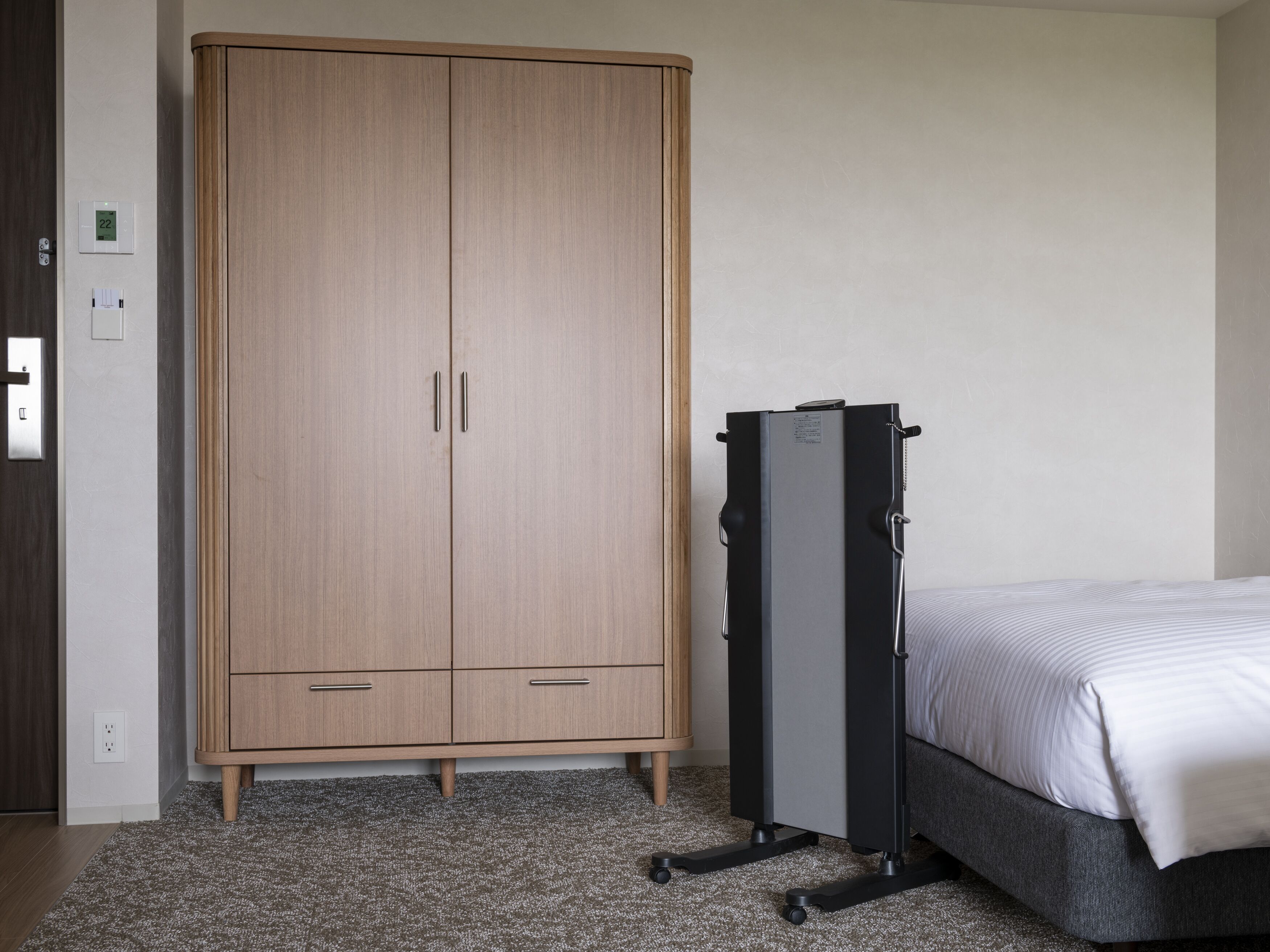 Une chambre à coucher avec un lit, une armoire et un bureau.
